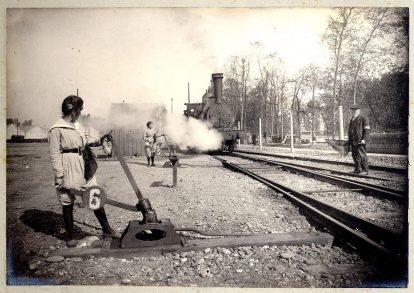 [Album de la poudrerie : femmes au travail]. Usine de produits explosifs, dite la Poudrerie Nationale, SNPE, 1 chemin de la Loge, Toulouse. Guerre 1914-1918. Deux femmes manipulant un levier d&rsquo;aiguillage lors du passage d&rsquo;un train.